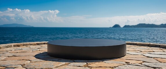 Empty round black podium on stone platform with sea island and blue sky background for product display.