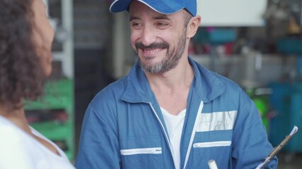 An auto mechanic and female customer in garage. The mechanic and customer Woman talking to a car mechanic in Car service center. - Powered by Adobe