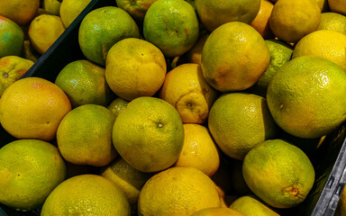 Juicy oranges tangerines in supermarket yellow orange background texture Mexico.