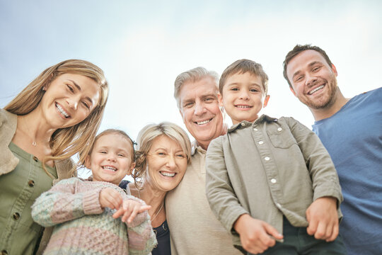 Happy portrait, children and big family with outdoor bonding time, love relationship and care for security. Below smile, generations and parents with kids for vacation together, blue sky and support