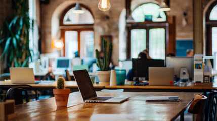 Modern coworking space with laptops and potted plants	