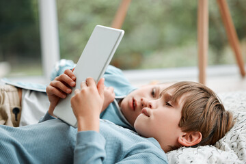 Children, siblings and lying with tablet on floor for entertainment, cartoon or streaming at home. Little boy or young kids relaxing with technology for online subscription, movie or series at house
