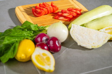 Fresh Vegetables and Fruits expertly displayed on a Cutting Board next to Ripe Tomatoes