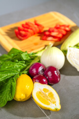 An array of vibrant vegetables and fresh ingredients neatly arranged on a wooden cutting board