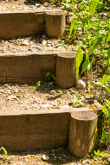 A fragment of old steps made of boards, round timber and crushed stone in the forest