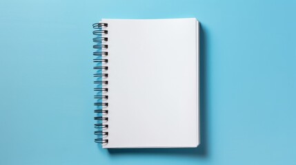 Open spiral notebook from above on blue backdrop