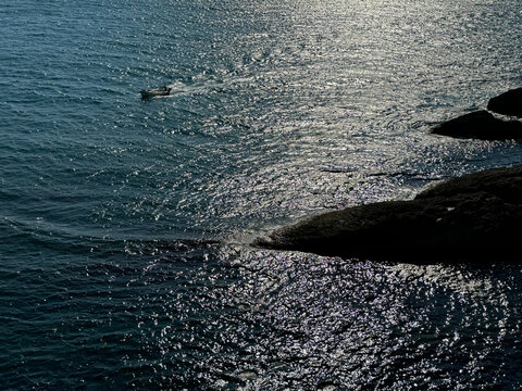 Shiny sea and rocky coast at evening 