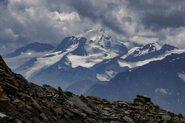 Layers of Austrian Alpine rocks and mountains stretch into the distance, showcasing the geological complexity of the region.