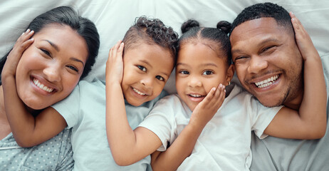 Top view, happy family and portrait of kids in bedroom for connection, support and parents laugh. Face, father and mother with children above for love, care and relax with siblings in home together