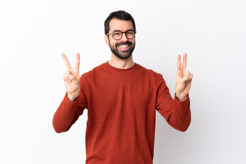 Caucasian handsome man with beard over isolated white background showing victory sign with both hands