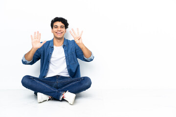 Obraz premium Venezuelan man sitting on the floor counting nine with fingers