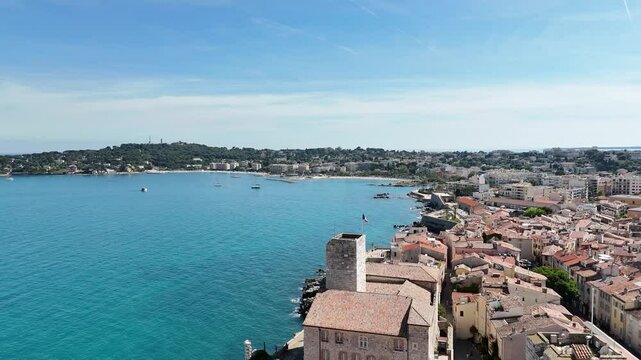 Drone shot of Antibes, France, highlighting a historic church and the stunning C&ocirc;te d'Azur coastline along the Mediterranean Sea.