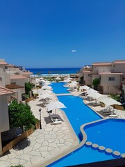 Serene poolside oasis with palm trees and lounge chairs, perfect for relaxation and vacation concepts.