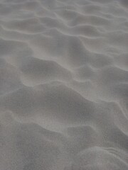 Rippled beach sand close up photo. Natural vertical wavy textured background.