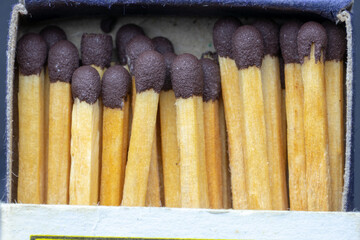 Set of wooden matchsticks with brown colored explosive together and lined up.