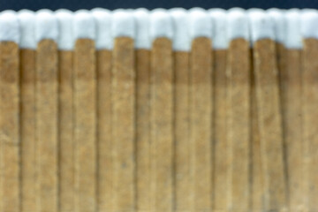 Set of wooden matches with head or white flammable material.blurred image.