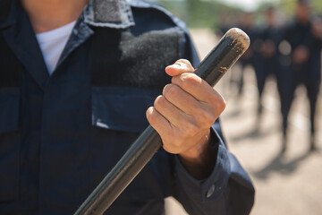 Riot police practice using batons in the field