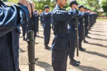 Riot police practice using batons in the field