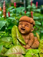 Obraz premium A statue in Thailand between leafs