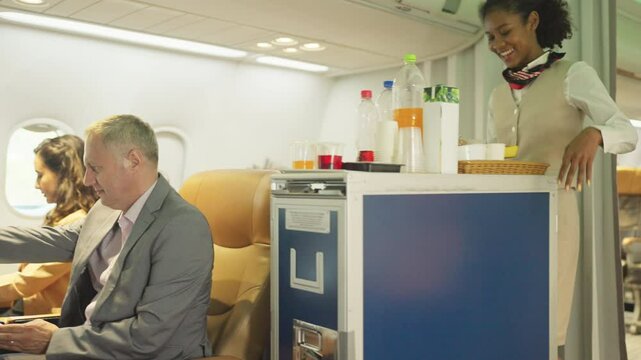 Side view Air hostess haul trolley in the airplane during service of food and drinking to the passenger.