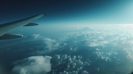 Obraz premium Aerial view from a plane window with wing, clouds, and Earth's curve visible, capturing a space-like high-altitude scene