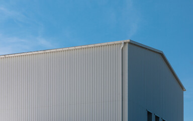 fragment of an industrial building covered with white sheet metal 