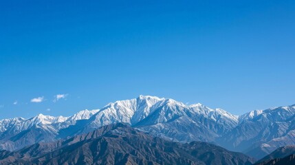 Fototapeta premium Snow-capped mountains under a clear blue sky