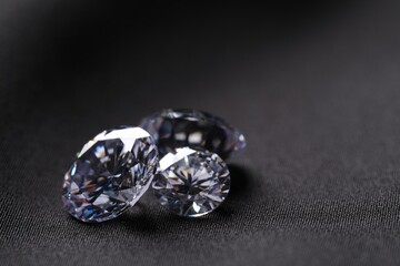 Many beautiful shiny diamonds on black fabric, closeup