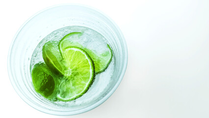 Lime slices in a glass of sparklin water  on the white background and copy space
