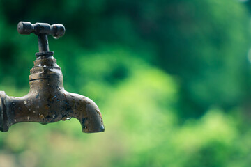 The hand of a child turning on water from a faucet that had no water during a shortage in order to drink.