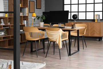 Interior of stylish office with workplace and shelf unit