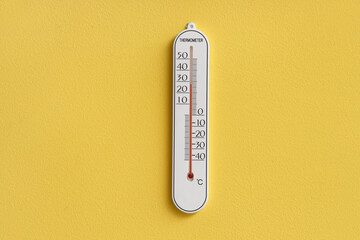 Home thermometer on yellow wall