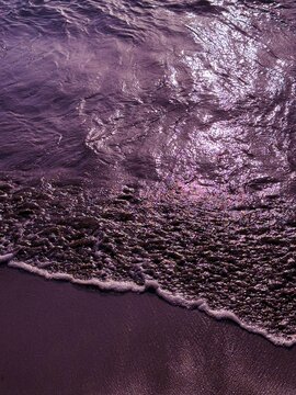 Purple sea waves on the beach at evening dusk 