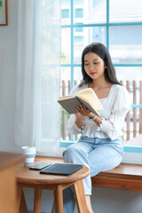 Young asian businesswoman enjoying to reading literature the book and relaxation with drinking...