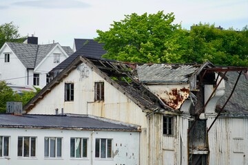 View of old buildings in Gomalandet surrounded by green trees. Kristiansund, Norway