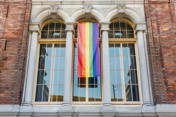 Fototapeta premium lgbt flag hanging in the window of historic court house building, front view