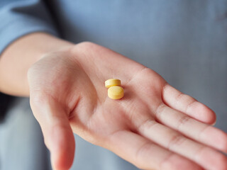 家にいる子供が薬の錠剤を持つ様子