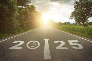 New year 2025 straightforward for environmental sustainability concept. Text 2025, save the world, leaf icon on the road in the middle of asphalt road at sunset. Ecological balance, sustainability.