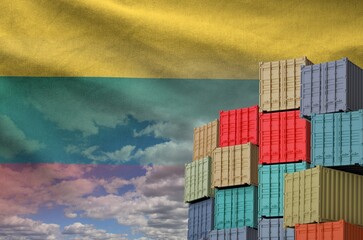 Lithuania flag and big stack of shipping cargo containers in docks with sky background close up