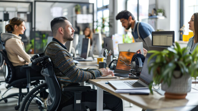 Inclusive Workplace: Wheelchair User Engaged in Teamwork at Contemporary Office Desk with Coworkers