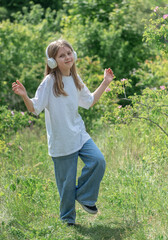 A child  with headphones listening to music and dancing