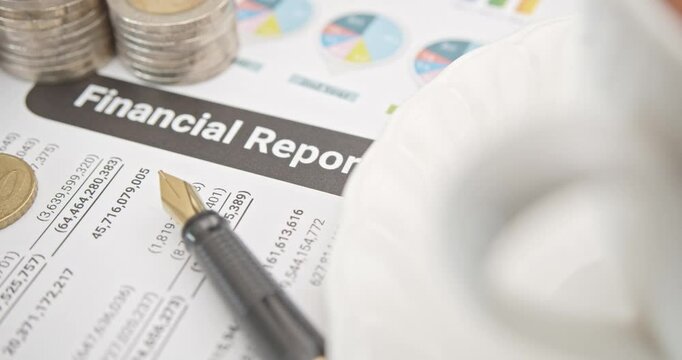 Pen atop a business or corporate financial report, anticipating review by financial and investment experts prior to public disclosure. Illustrating financial analysis and investment insight concept.