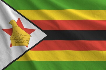 Zimbabwe flag depicted on folded wavy fabric of old cloth close up