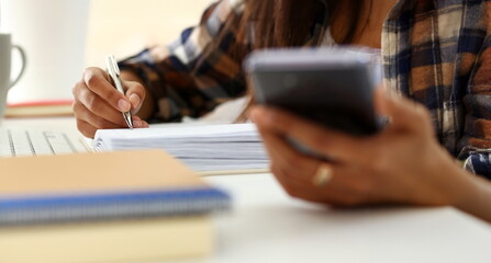 Arm of black woman hold silver pen workplace writing something in diary closeup
