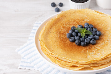 Crepes, thin pancakes with blueberry jam and fresh berries, with copy space for text