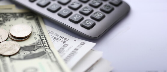 Paper bill lying at table with calculator and us dollar notes closeup