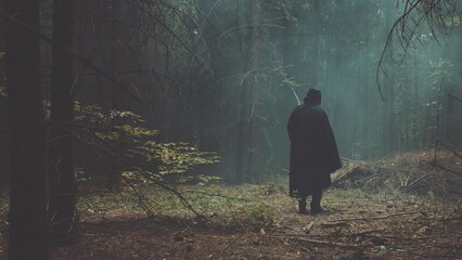 A man in a black cloak in the forest meets girl and they both flee forest. The dramatic scene for...
