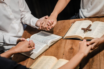 A group of people sits together, reading the Bible and praying. Their expressions reflect deep faith and friendship, creating a serene atmosphere filled with love, hope, and spiritual connection.