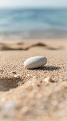 Obraz premium Minimalist close-up of a smooth white pebble balanced on a larger rock, emphasizing natural simplicity and balance