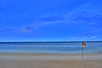 Lone flag adorns the peaceful coastline.